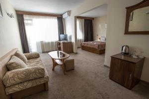 - un salon avec un canapé et un lit dans l'établissement Park Hotel Ivailo, à Veliko Tarnovo