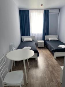 a room with two beds and a table and chairs at Dinamo in Odesa