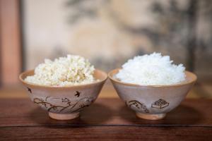 OSAKA NOSE Farmer's Guest House　YASUDA FARM في Nose: وعاء اثنين من الأرز على طاولة