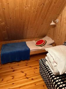 a room with a bed and a bowl of watermelon at Domek całoroczny HAWAJE nad jeziorem Kazub in Cieciorka