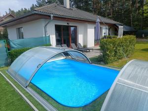 ein blauer Pool vor einem Haus in der Unterkunft Relaxklub villa s wellness in Třemošná