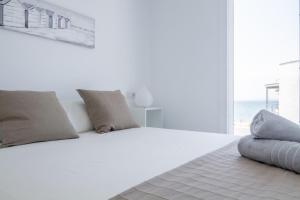a bedroom with a white bed with a view of the ocean at Vista Roses Mar - Vent De Mar in Roses +40 photos