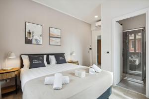 a bedroom with a large white bed with towels on it at limehome Rome via dei Reti in Rome