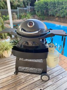 a grill sitting on a table next to a pool at Studio 26: Central, Hampton’s Poolside Hideaway in Coffs Harbour