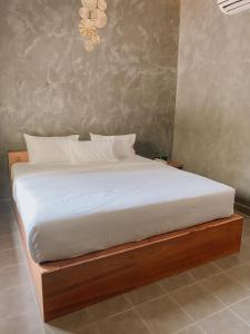 1 dormitorio con 1 cama con marco de madera en Tachang Airport Hotel en Hat Yai