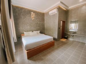 a bedroom with a white bed in a room at Tachang Airport Hotel in Hat Yai