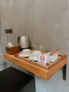 a wooden table with dishes and a no smoking sign on it at Tachang Airport Hotel in Hat Yai