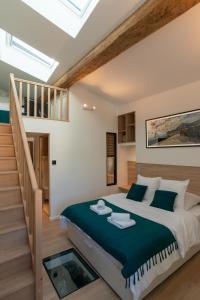 ein Schlafzimmer mit einem großen Bett und einer Treppe in der Unterkunft Le Repaire du Pic, gîte de charme 3 étoiles in Notre-Dame-de-Londres