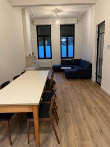 een woonkamer met een tafel en stoelen en een bank bij Astrid in Mechelen