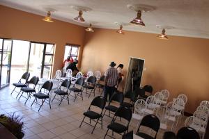 a man standing in a room with chairs and tables at Boikhutsong Bed & Breakfast in Maseru