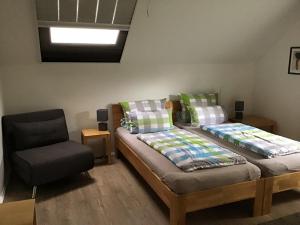 クサンテンにあるFerienwohnung HeeserBerg Xantenのベッドと椅子のある寝室