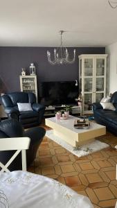 Sala de estar con sofás y mesa de centro en Maison quiétude, en Chavanoz