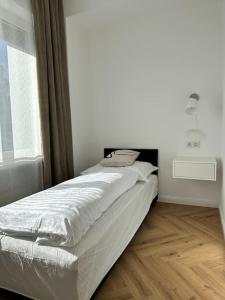 un letto bianco in una stanza con finestra di MIRABELLE Homes a Salisburgo