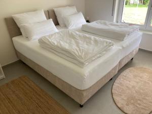 2 bedden met witte lakens en kussens in een kamer bij Villa Emilia Rottweil in Rottweil
