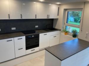 een keuken met witte kasten en een zwarte kachel bij Villa Emilia Rottweil in Rottweil