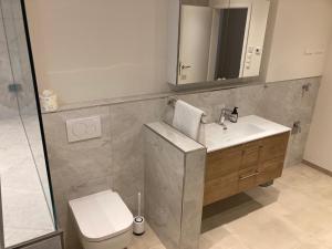 een badkamer met een wastafel, een toilet en een spiegel bij Villa Emilia Rottweil in Rottweil
