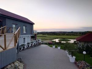 ein Gebäude mit einem Gehweg neben einem Fluss in der Unterkunft Duarto house, Sauna and Hot Tub in Šiaudinė