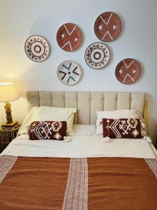 a bedroom with a bed with plates on the wall at Les cigales - souplex cosy et calme in Mas-Saintes-Puelles