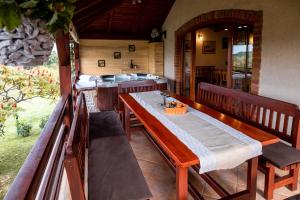 a porch with a table and benches and a tub at Holiday Home Vitis in Selnica