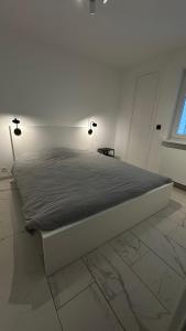 a bed in a white room with two lights on it at O9 KOK appt 3 chambres à 50 m de la mer in Koksijde