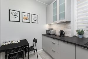 a kitchen with white cabinets and a black counter top at Lewicka 8 by Homeprime in Warsaw