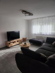 a living room with a couch and a flat screen tv at Apartment am Südhang 2 in Dinkelsbühl
