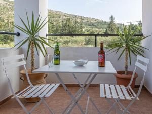 una mesa blanca con 2 botellas y 2 sillas en Villa Angelos with private gated pool, en Almyrida