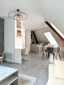 a living room with a table and a dining room at Charmant duplex en centre-ville in Brive-la-Gaillarde