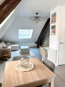 ein Wohnzimmer mit einem Tisch und einem Sofa in der Unterkunft Charmant duplex en centre-ville in Brive-la-Gaillarde