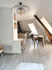ein Esszimmer mit Tischen, Stühlen und einer Decke in der Unterkunft Charmant duplex en centre-ville in Brive-la-Gaillarde
