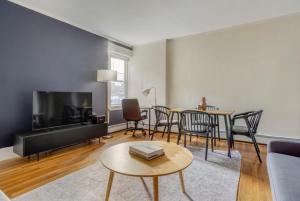 a living room with a tv and a table and chairs at South Boston 3br fully furnished equipped BOS-928 in Boston