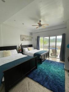 1 Schlafzimmer mit 2 Betten und einem blauen Teppich in der Unterkunft Lopez Beach Resort in Sipalay