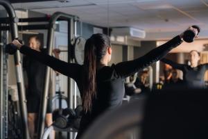 une femme dans une salle de sport avec les bras tendus dans l'établissement Son Spa, à Son