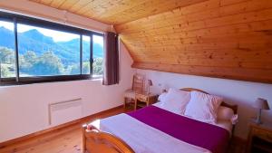 - une chambre avec un lit et une grande fenêtre dans l'établissement Gîte Laguës, à Poueyferré