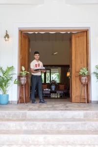 un homme debout à l'entrée d'une maison dans l'établissement ama Stays & Trails Palmeira De Socorro , Goa, à Vieux-Goa 74 autres photos