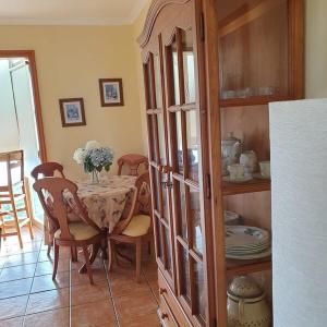 a dining room with a table and a china cabinet at Casa Sabela con vistas al MAR in Arecida