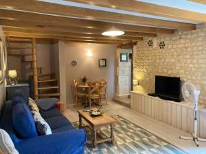 Una sala de estar con un sofá azul y una mesa. en Stunning rural gem with pool in southwest France, en Brie-sous-Barbezieux