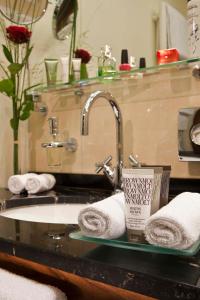 a bathroom counter with a sink with towels on it at MAXIMILIAN MUNICH Apartments & Hotel in Munich