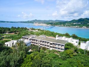 un edificio de apartamentos en una colina junto a un cuerpo de agua en E-horizon Resort Condominium Sesoko en Motobu