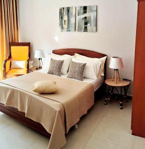 een slaapkamer met een groot bed en 2 stoelen bij Luxury Apartment in Kaduwela