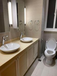 a bathroom with two sinks and a toilet at Luxury Apartment in Kaduwela