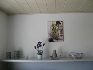 un estante con flores y una foto en una pared en Ferienwohnung Prior, en Bad Emstal