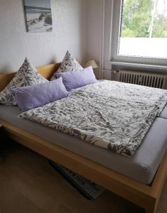 Una cama con almohadas moradas en un dormitorio en Ferienwohnung Prior, en Bad Emstal