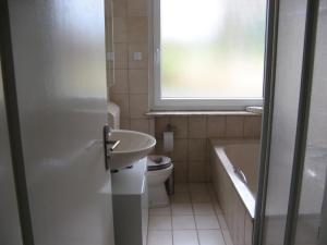 baño con lavabo y aseo y ventana en Ferienwohnung Prior, en Bad Emstal