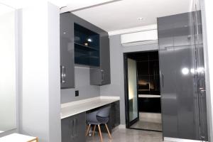 une cuisine avec des armoires noires et un comptoir blanc dans l'établissement The Residence Villa, à Musina