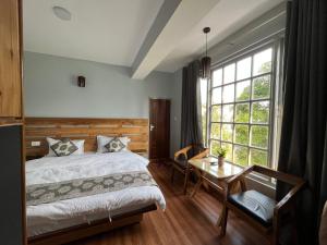 een slaapkamer met een bed, een tafel en een raam bij Bahar Retreat And Spa , Gangtok in Gangtok