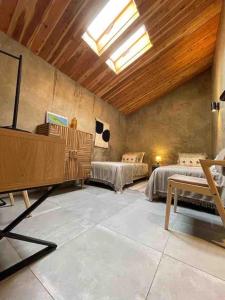 a bedroom with two beds in a room with a ceiling at Casa da Esquila Ilha do Pico 2 in Cais do Pico