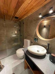 a bathroom with a sink and a toilet and a mirror at Casa da Esquila Ilha do Pico 2 in Cais do Pico