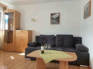 - un salon avec un canapé et une table avec des verres à vin dans l'établissement Appartements Bodenland, à Wildschönau