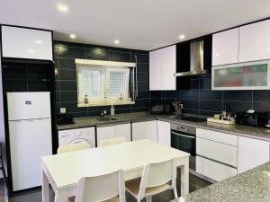 a kitchen with a white table and white appliances at Atlantic Surf Apartment in Ferrel